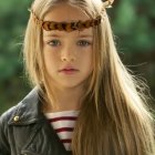 Young girl with blonde hair in green jacket outdoors