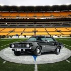 Black Chevrolet Camaro on Football Field with Red Stripes