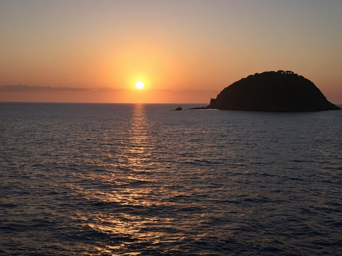 Serene Sunset Over Tranquil Ocean with Distant Island