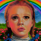 Young girl in vintage dress with rainbow backdrop