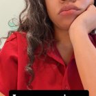 Contemplative Individual with Curly Hair in Vibrant Setting