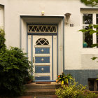 Charming Facade with Vintage Door and Lush Vines