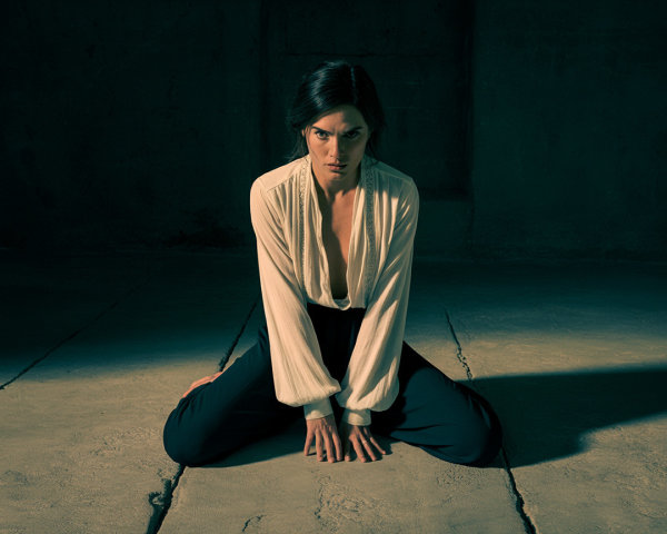 Woman in Dimly Lit Room with Intense Gaze