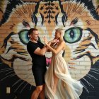 Man and woman pose before vibrant tiger mural
