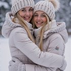 Young Women in Matching Hoodies on Snowy Beach