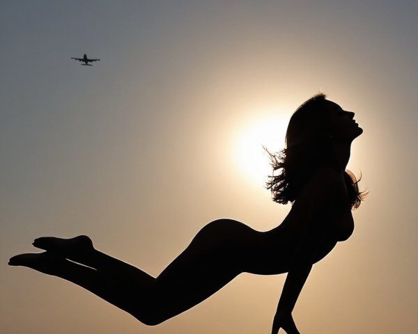 Silhouetted Figure Against Vibrant Sunset Background