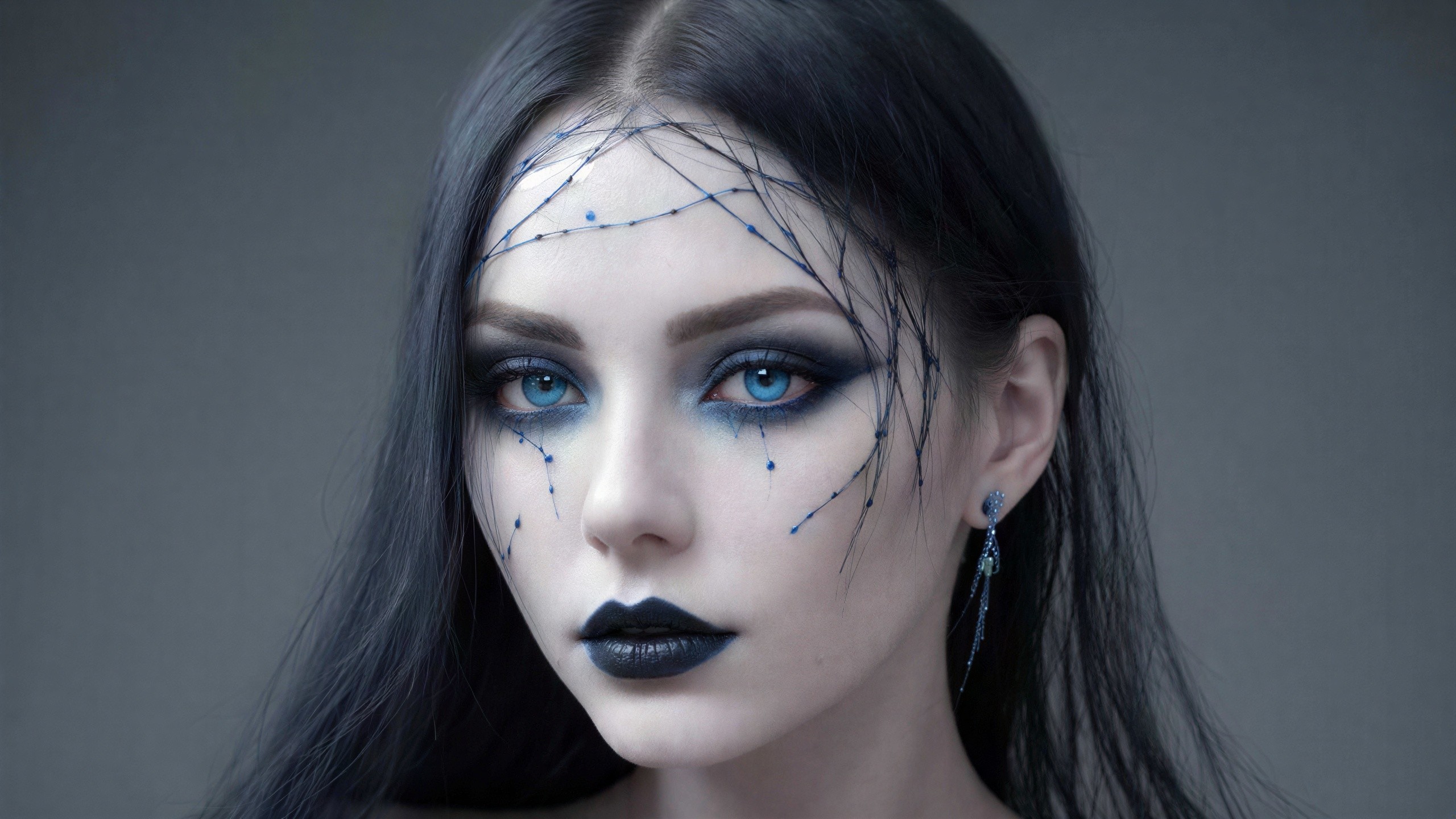 Close-up portrait of a woman with dramatic blue makeup