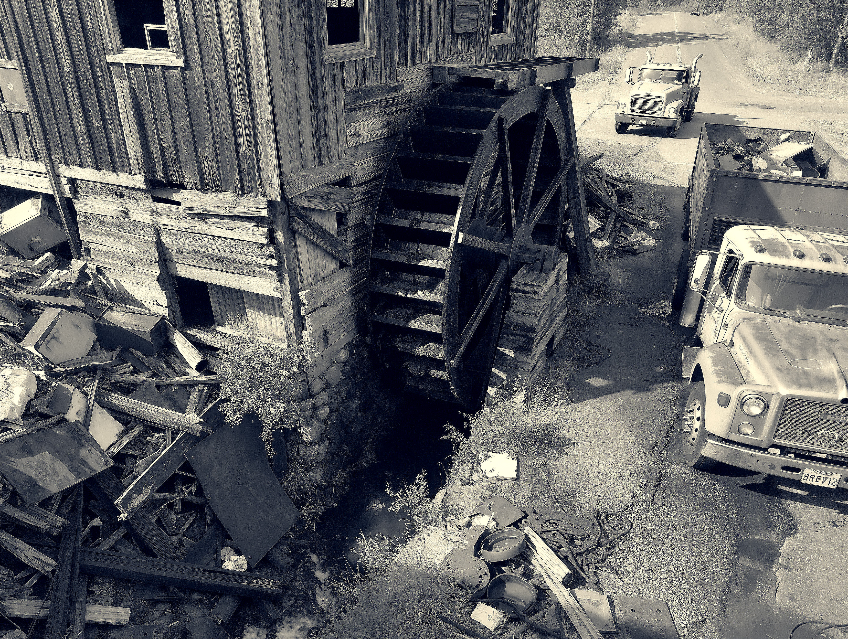 Rustic Wooden Building with Waterwheel in Junkyard