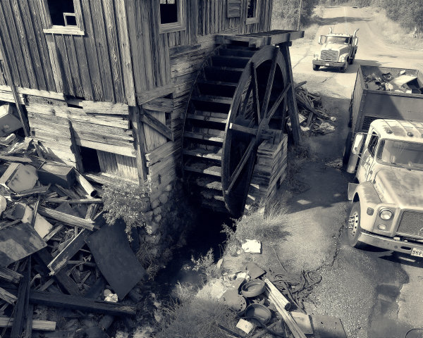 Rustic Wooden Building with Waterwheel in Junkyard