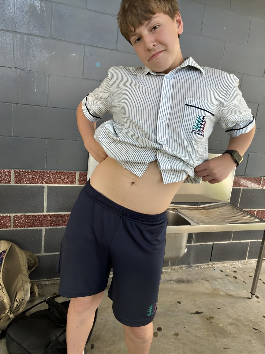 Young boy in school attire poses by water fountain