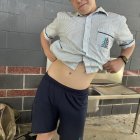 Young boy in school attire poses by water fountain