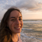 Young woman on a beach at sunset with waves