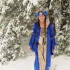 Young woman in blue gown in snowy forest setting