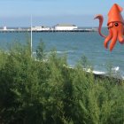 Surreal Seascape with Vibrant Orange Octopus and Pier