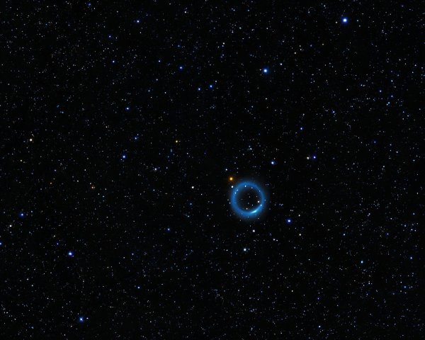 Dark Nebula Surrounded by Blue Halo and Stars