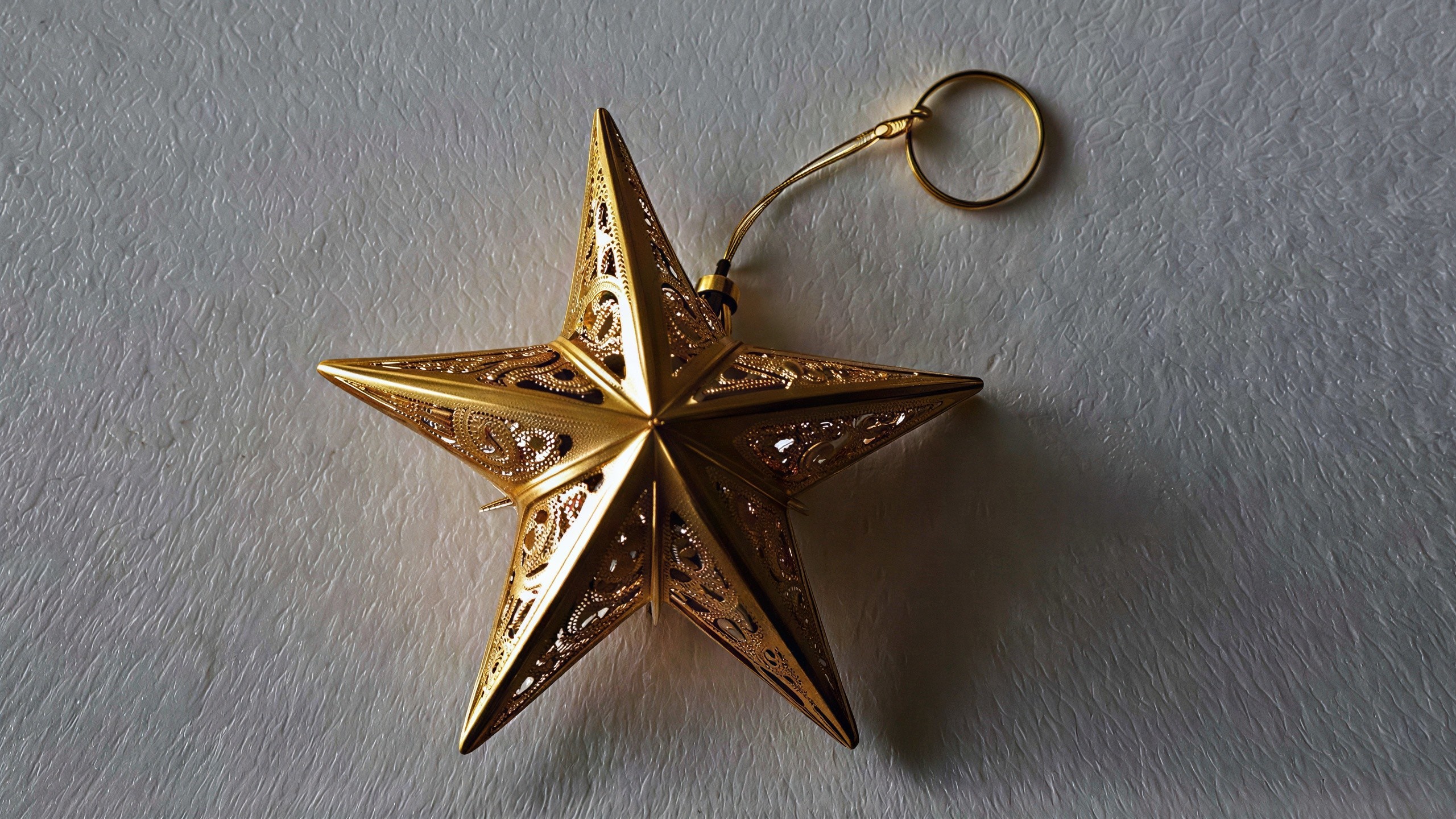 Close-up of a golden star ornament on textured background