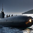 Dark Submarine Surfaces in Calm Waters with Mountains