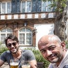 Outdoor Scene of Two Men Enjoying Drinks Together