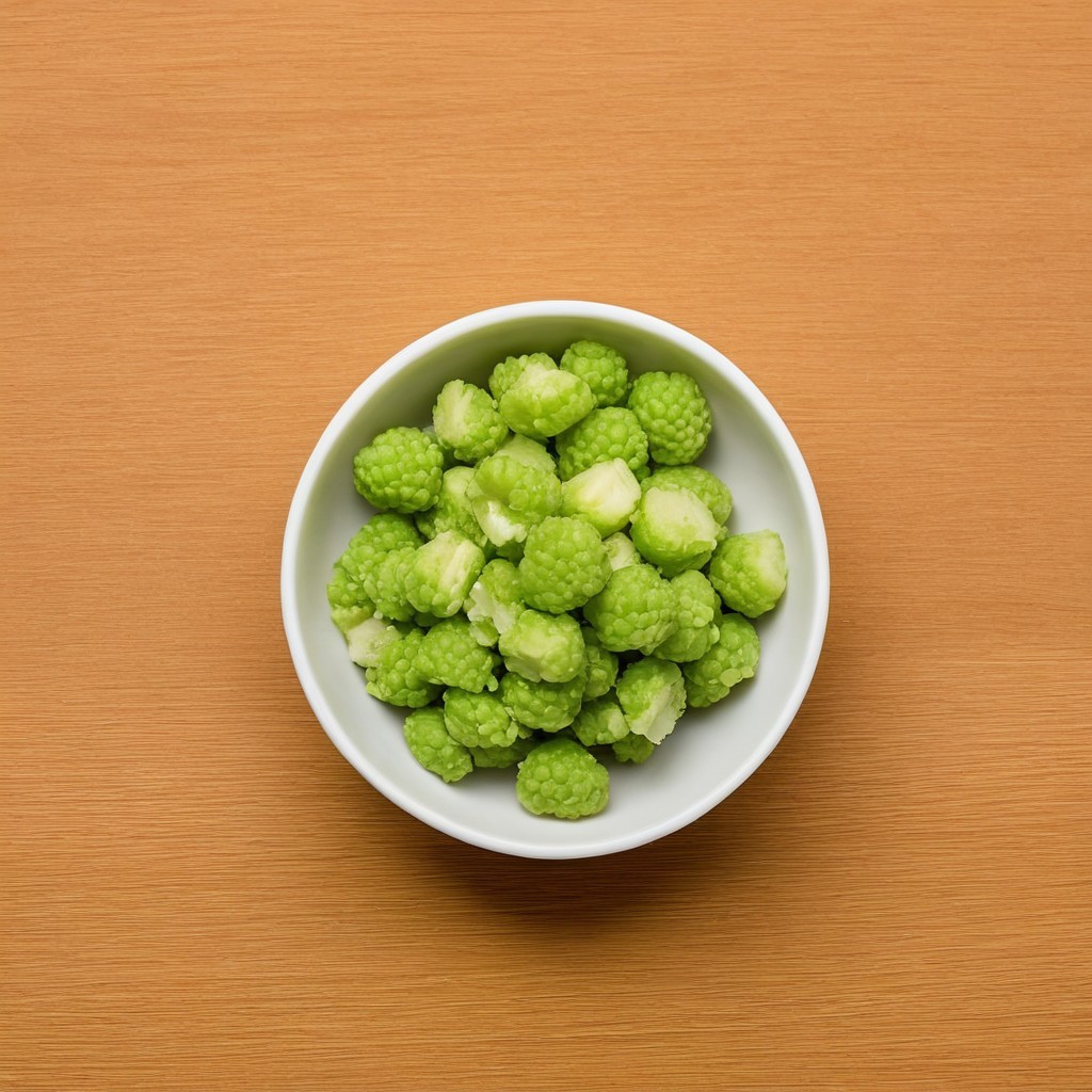 Vibrant Green Textured Fruit in White Bowl on Wood