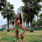 Woman in Floral Dress with City Skyline and Palm Trees