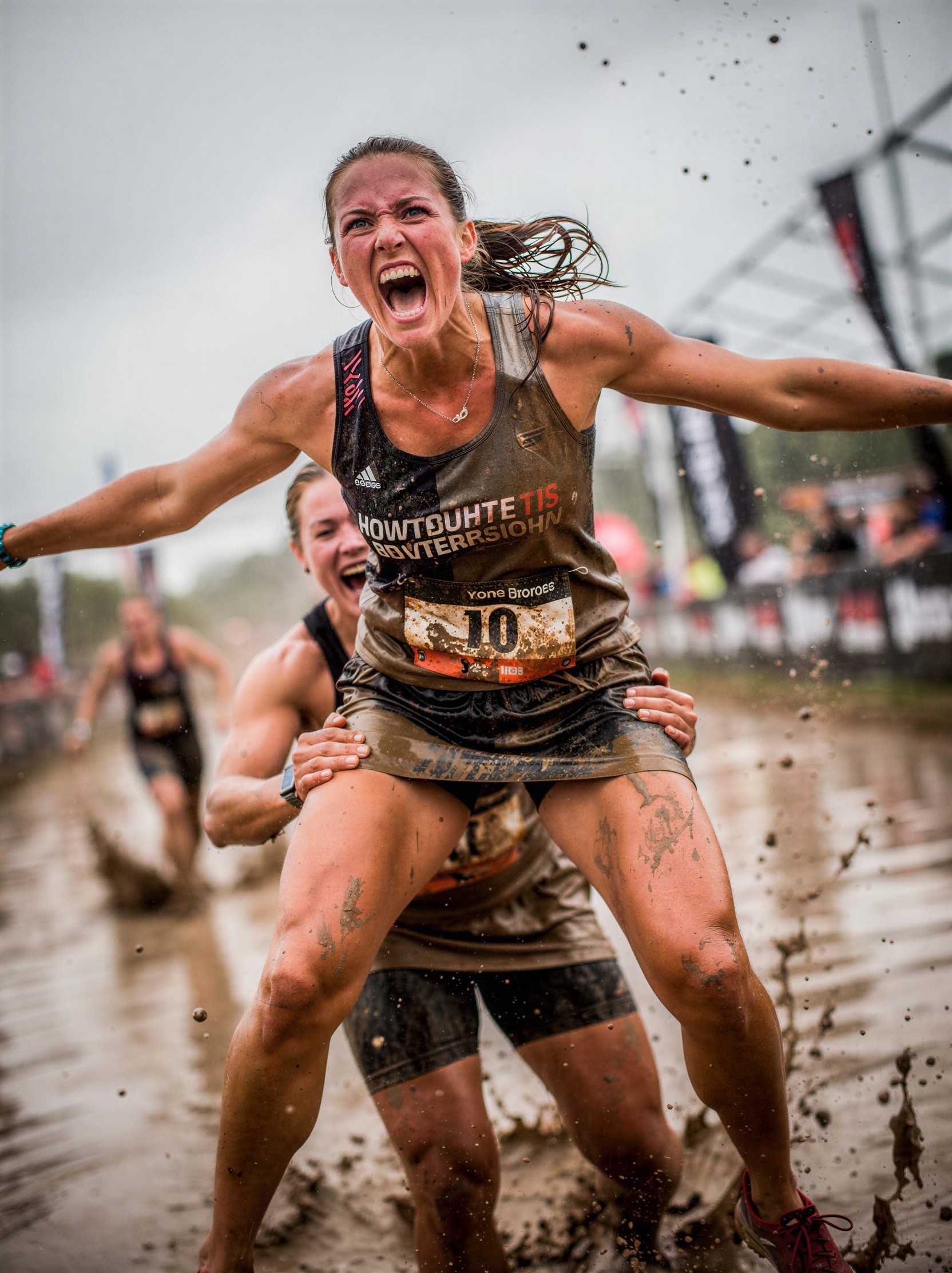 Women Running in Muddy Race with Joyful Expressions
