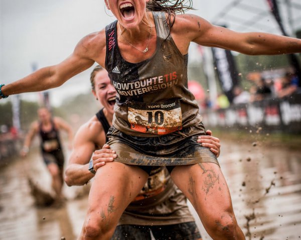 Women Running in Muddy Race with Joyful Expressions
