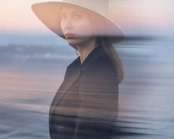 Portrait of a Woman in Hat by Tranquil Seascape at Dusk