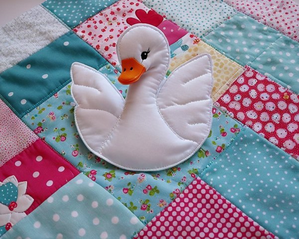 Colorful patchwork quilt with swan appliqué design
