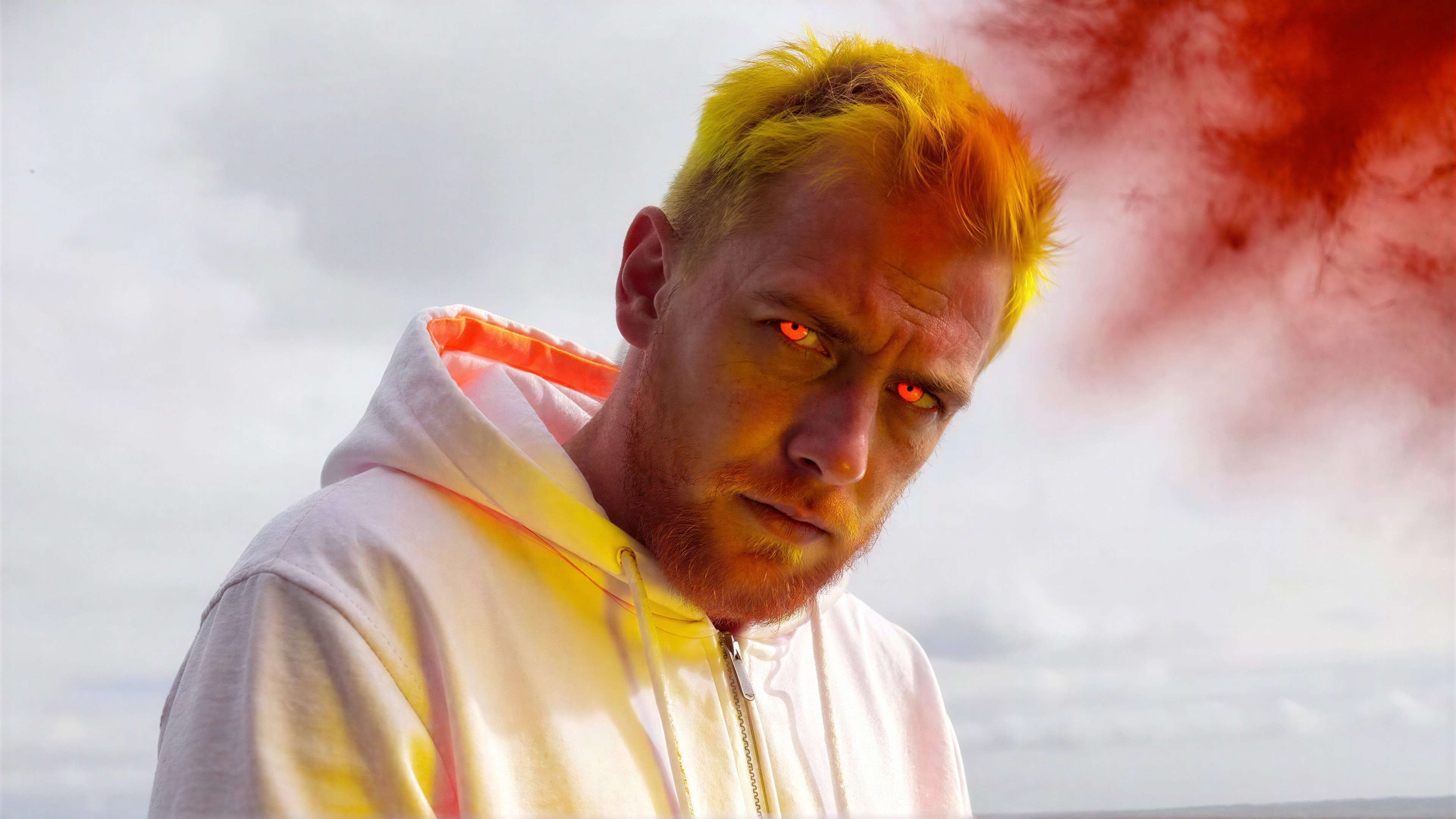 Close-up of a man with orange beard and pink eyes
