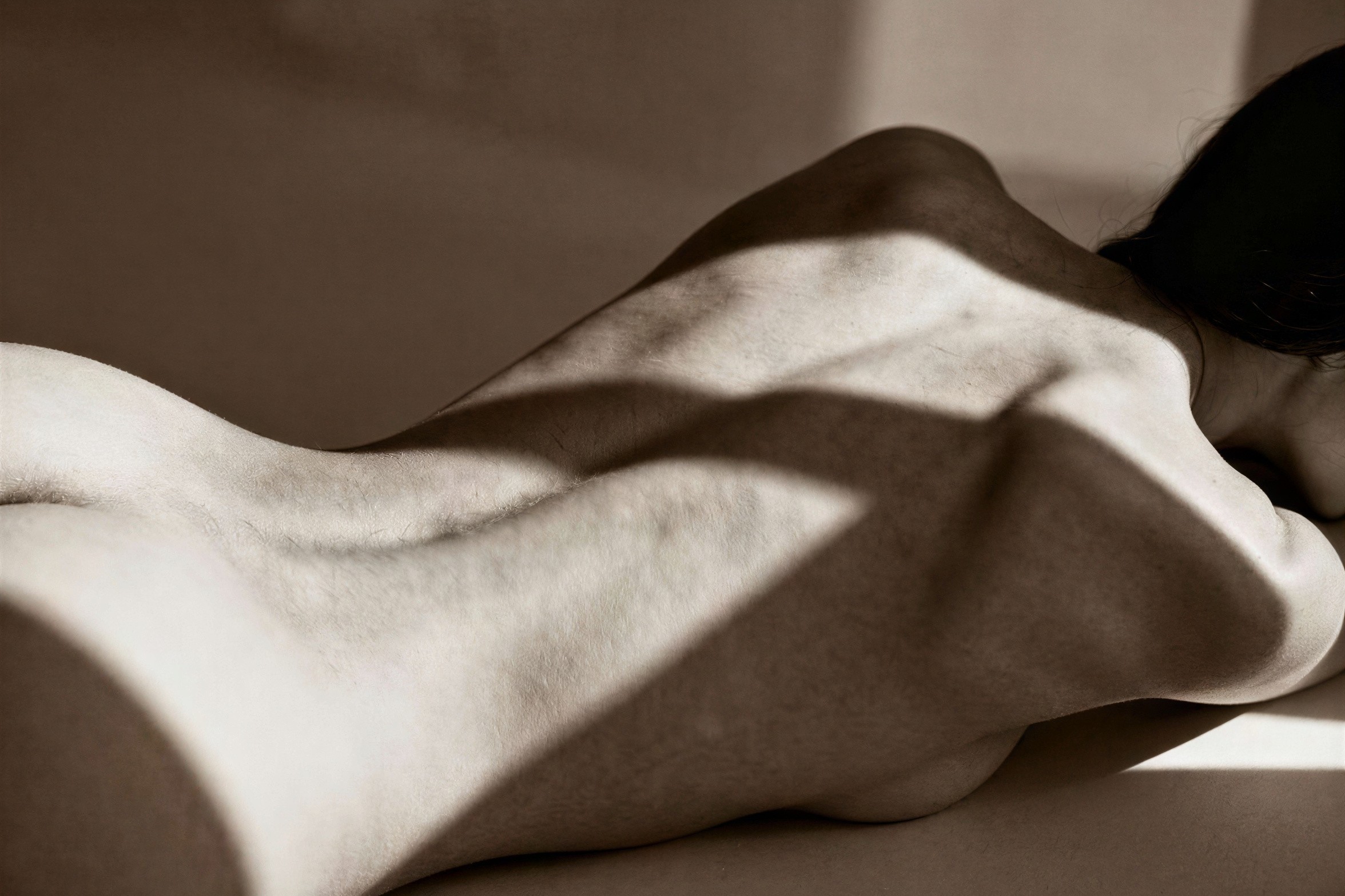 Close-up of a Sleeping Woman's Back in Warm Light