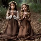 Young girls in elegant dresses kneel in tranquil forest