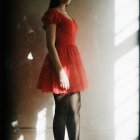 Confident Woman in Red Dress with Sheer Tights