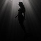 Underwater Scene Featuring a Silhouette of a Mermaid