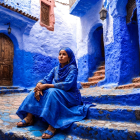 Woman in Blue Outfit in Serene Mediterranean Alleyway