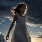 Young girl in white dress against dramatic sunset sky