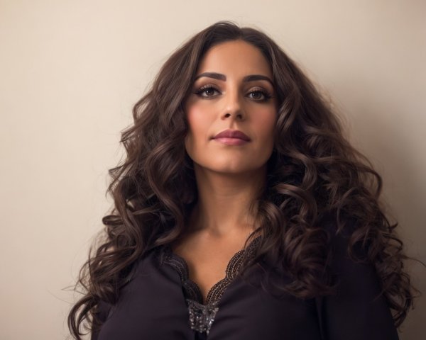 Confident Woman with Curly Hair in Elegant Outfit