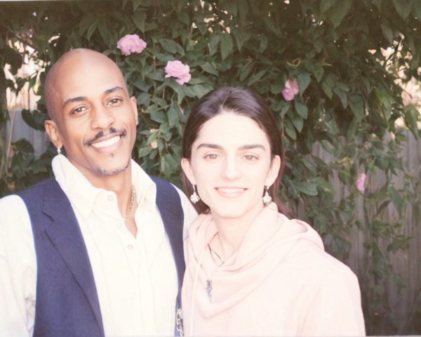 Smiling Couple Surrounded by Greenery and Roses