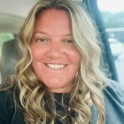 Smiling Woman with Long Blonde Hair in Soft Lighting