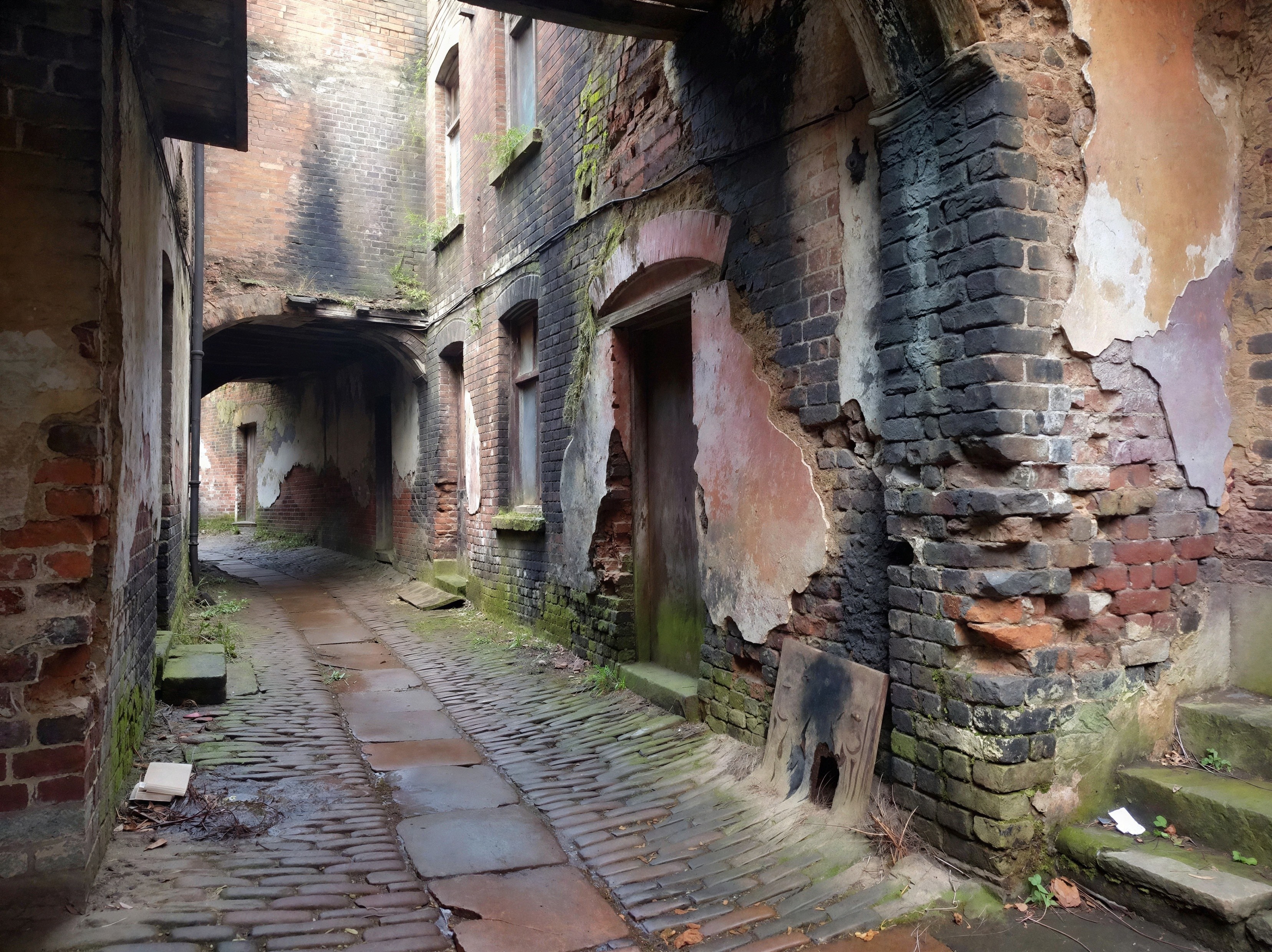 Narrow Cobblestone Alleyway with Decaying Brick Walls