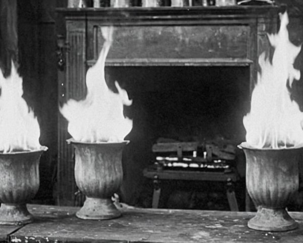 Flames on Antique Urns in a Dimly Lit Room