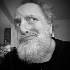 Young man with curly hair and beard in abstract setting