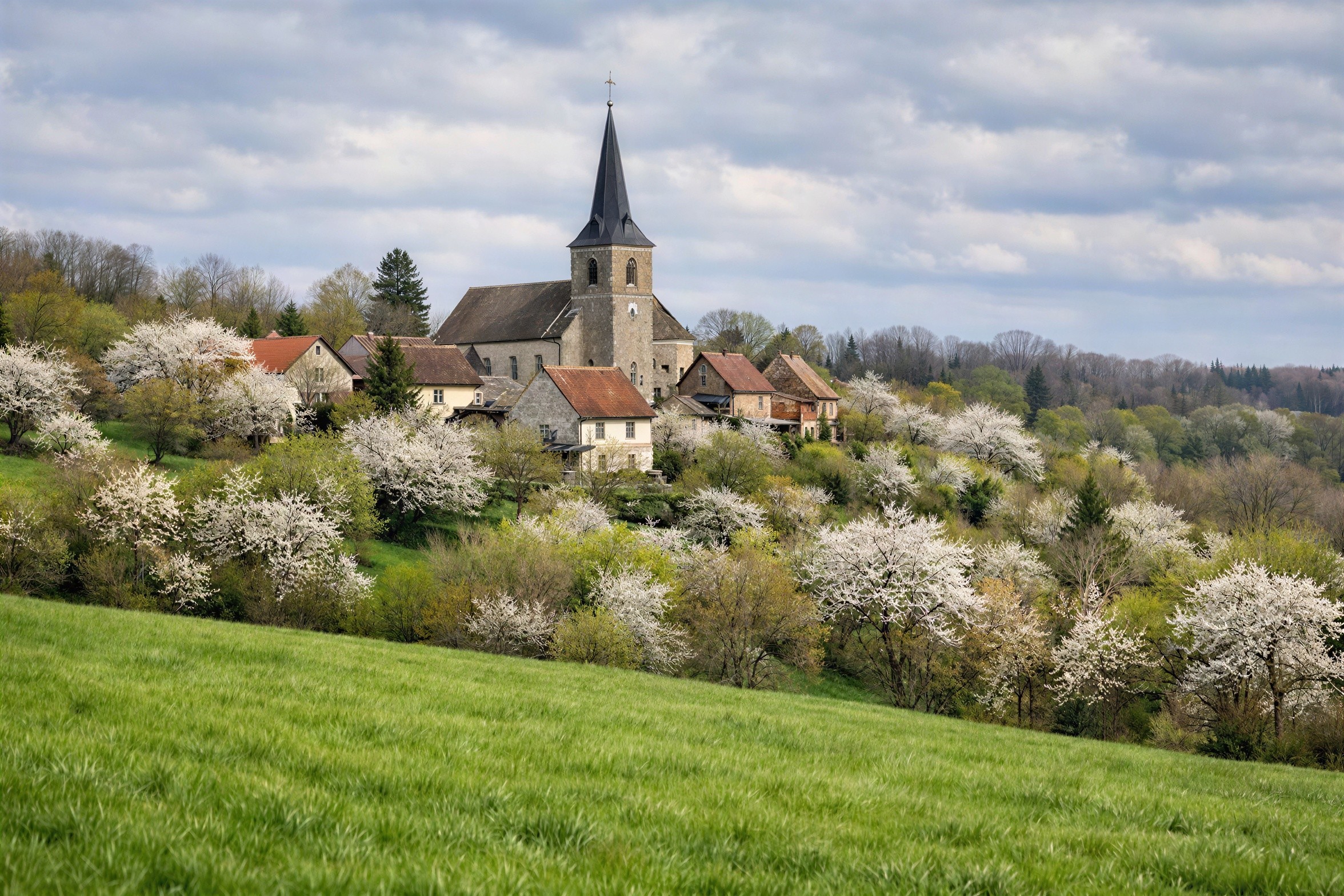 Hillside Village with Stone Church and Green Fields
