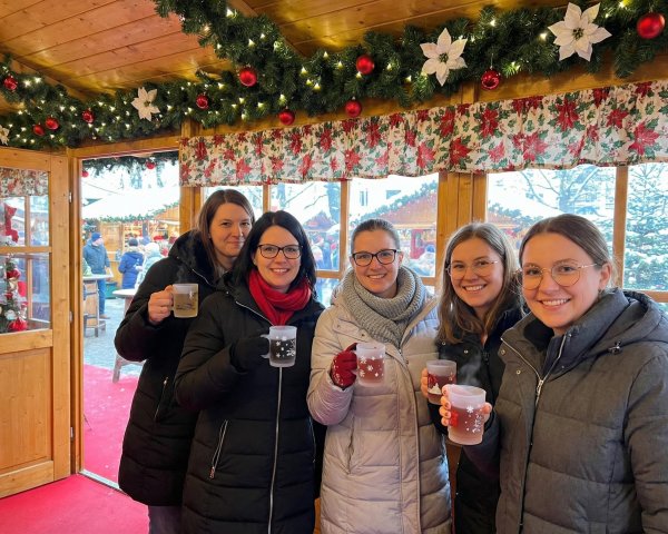 Young Women at Christmas Market Stall with Drinks