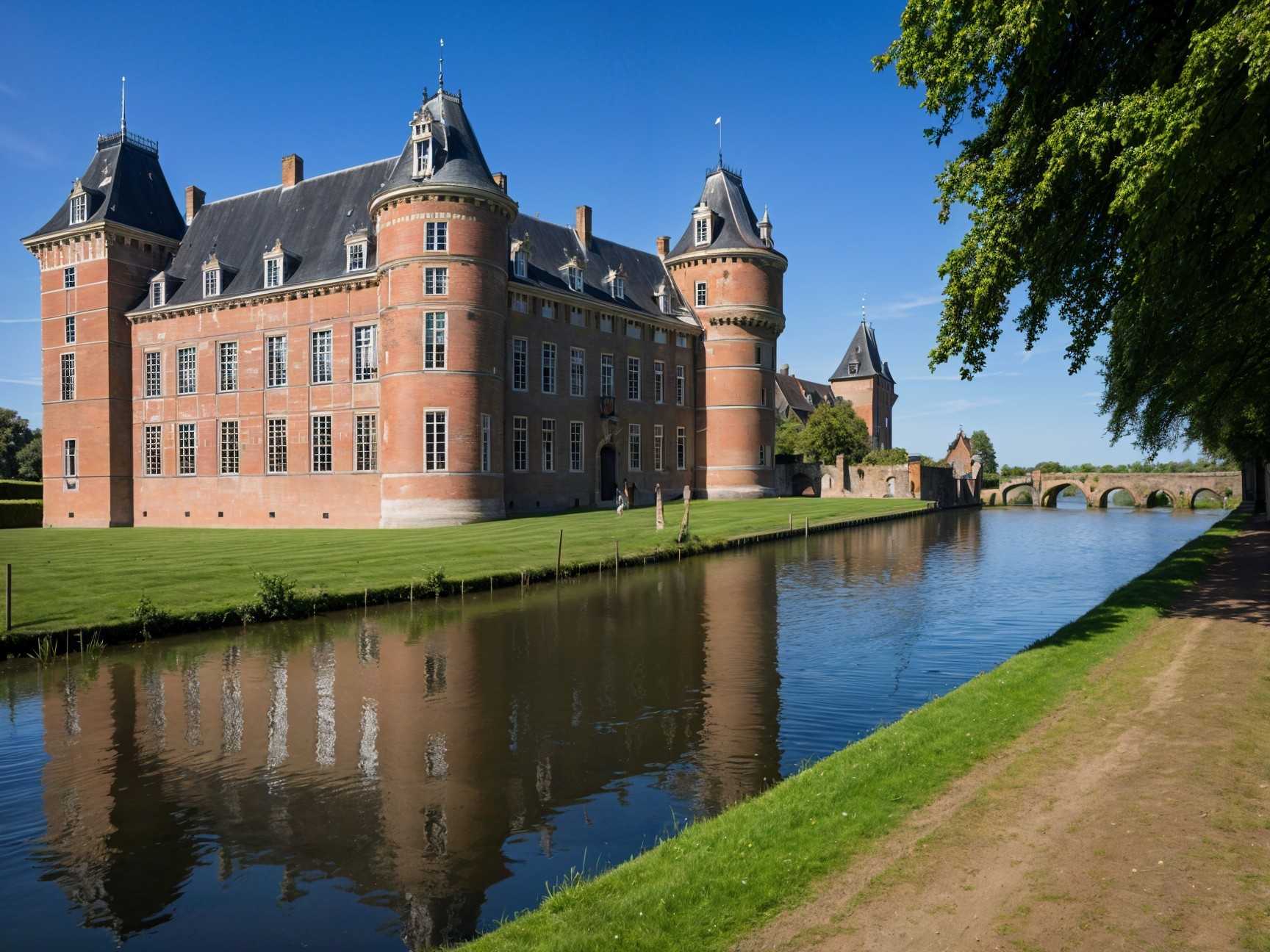 Brick castle beside tranquil waterway with reflections
