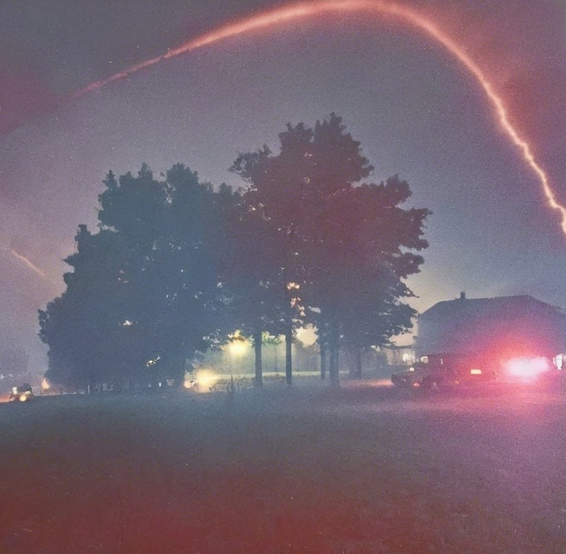 Surreal Night Scene with Lightning and Silhouetted Trees