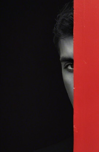 Close-up of a face partially hidden by red surface