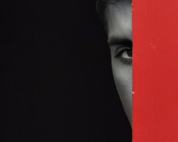 Close-up of a face partially hidden by red surface