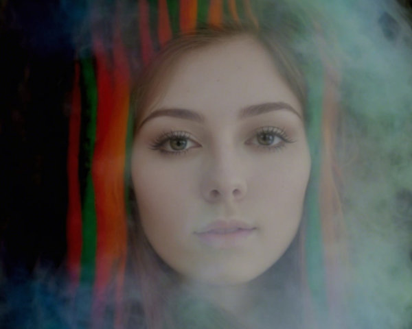 Young woman with colorful hair and ethereal smoke