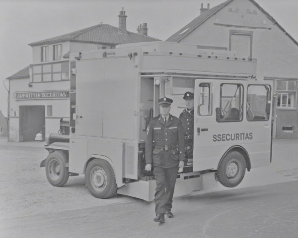 Black-and-White Scene of Security Officers and Vehicle