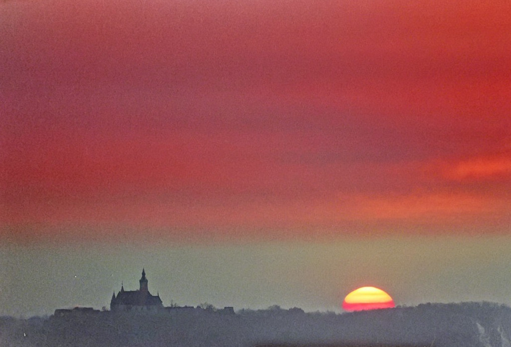 Vibrant Sunset Over Castle on a Foggy Hilltop